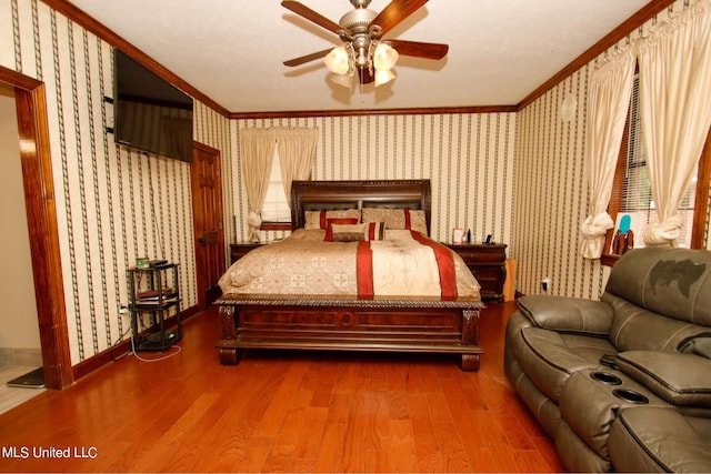 bedroom featuring ornamental molding, wood-type flooring, and ceiling fan