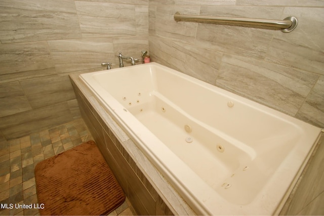 bathroom with a relaxing tiled tub and tile walls