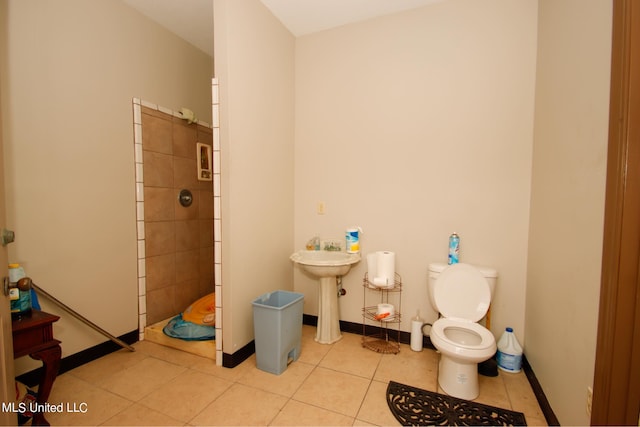 bathroom featuring toilet, walk in shower, sink, and tile patterned floors