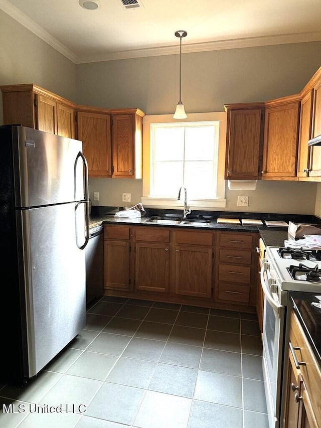 12 N Oak St, Vidalia, LA 71373 - kitchen with ornamental molding, stainless steel appliances, dark tile patterned floors, sink, and hanging light fixtures