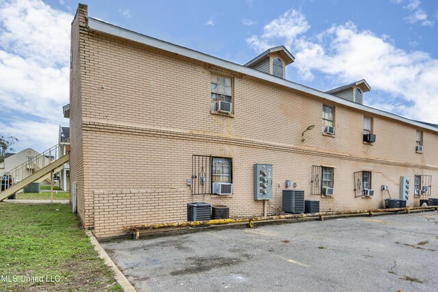 rear view of house with central AC unit and cooling unit