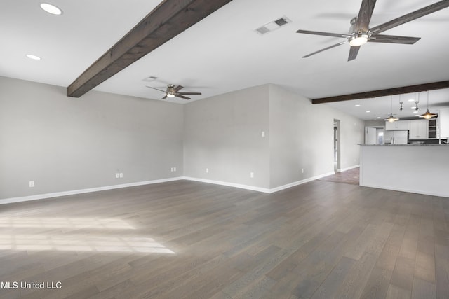 unfurnished living room with ceiling fan, dark hardwood / wood-style flooring, and beamed ceiling