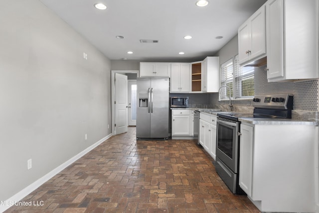 kitchen featuring sink, white cabinets, backsplash, and appliances with stainless steel finishes