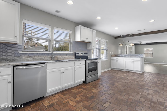 kitchen featuring sink, stainless steel appliances, white cabinetry, and backsplash