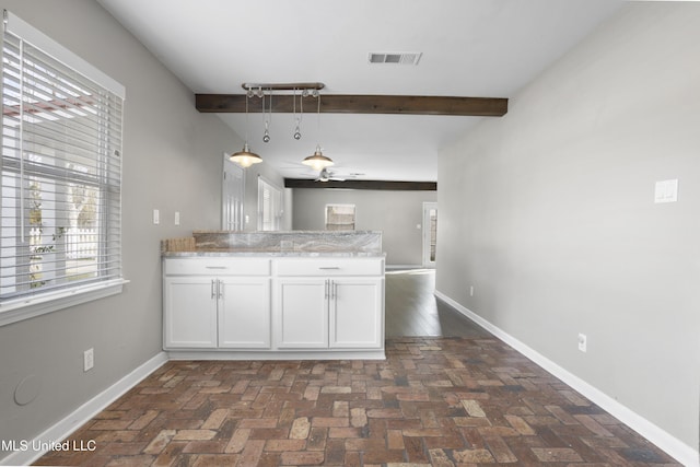 kitchen featuring white cabinetry, ceiling fan, pendant lighting, and beam ceiling