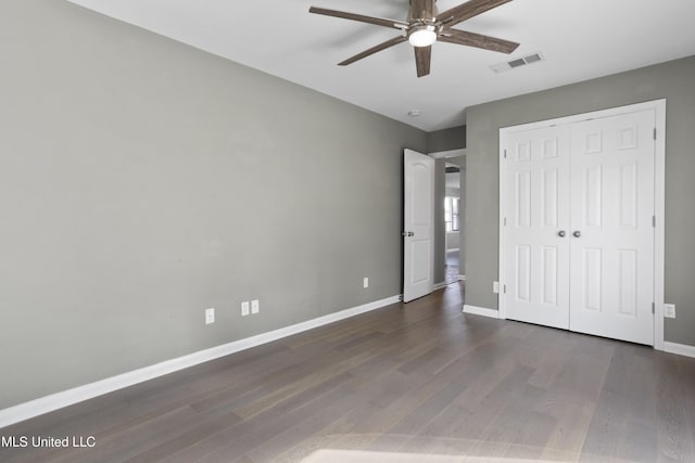 unfurnished bedroom featuring dark hardwood / wood-style flooring, a closet, and ceiling fan