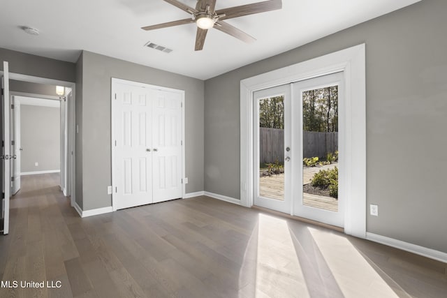 unfurnished bedroom with a closet, ceiling fan, dark wood-type flooring, french doors, and access to outside