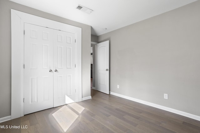 unfurnished bedroom featuring a closet and wood-type flooring