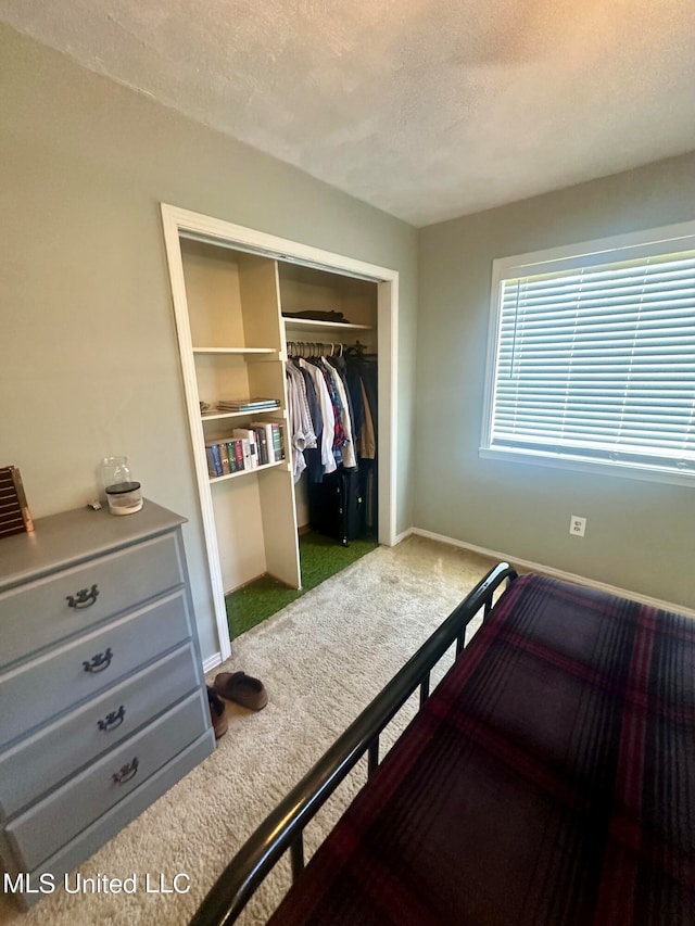 bedroom with a closet, a textured ceiling, and carpet flooring