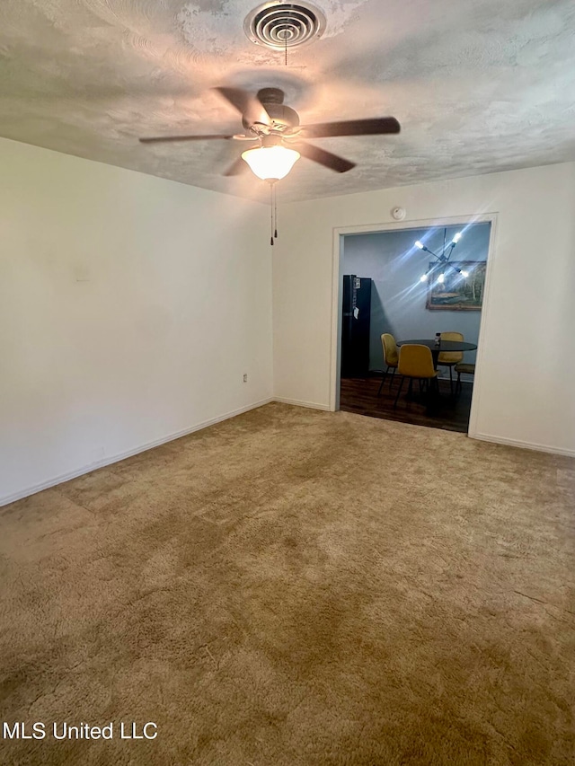 carpeted empty room with ceiling fan and a textured ceiling