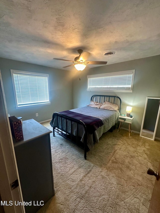 bedroom featuring carpet, a textured ceiling, and ceiling fan