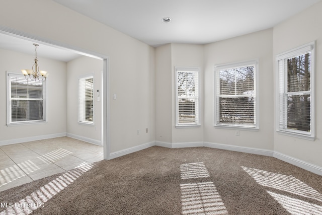 unfurnished room featuring a chandelier and light carpet