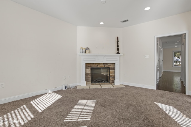 unfurnished living room with a stone fireplace and carpet flooring