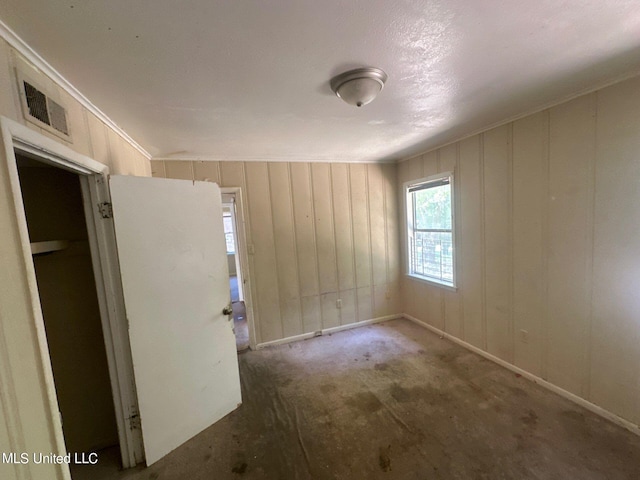 carpeted empty room with a textured ceiling