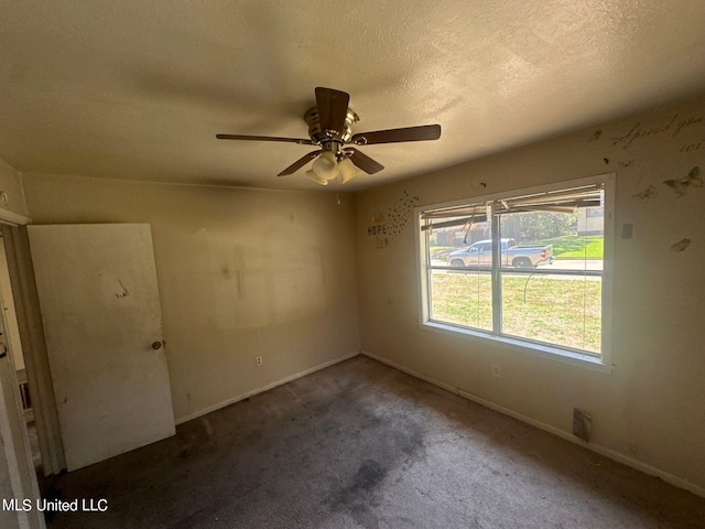 spare room with ceiling fan, carpet, and a textured ceiling