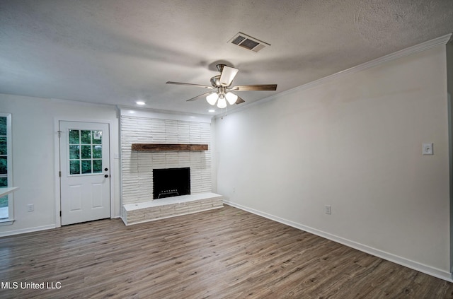 394 Woodcliff Dr, Jackson, MS 39212 - unfurnished living room featuring ornamental molding, a fireplace, a ceiling fan, visible vents, and wood finished floors