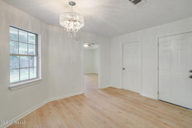 602 Hathaway Dr, Clinton, MS 39056 - empty room with light wood-style floors, a chandelier, and a textured ceiling