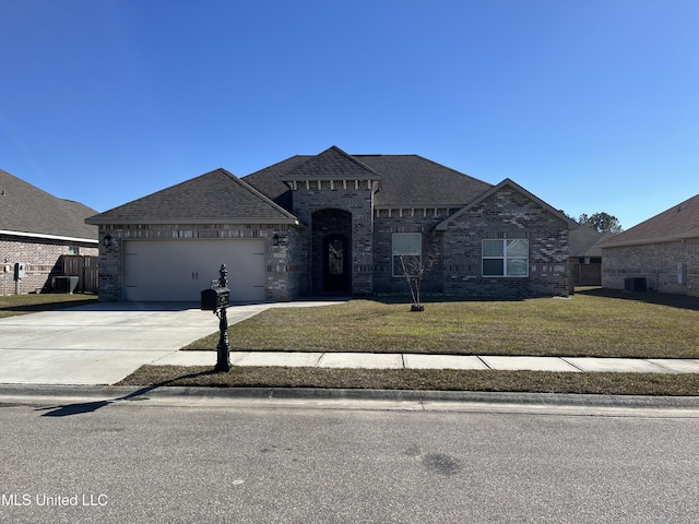 french provincial home with concrete driveway, brick siding, a front lawn, and an attached garage