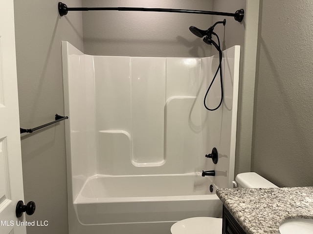 bathroom featuring shower / washtub combination, a textured wall, vanity, and toilet