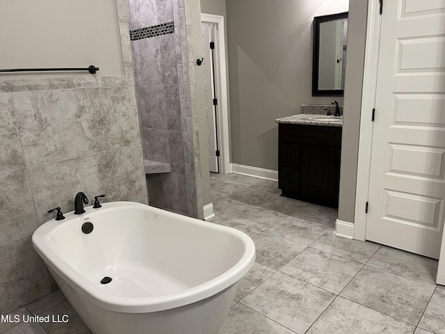 full bath featuring a soaking tub, tile walls, and vanity