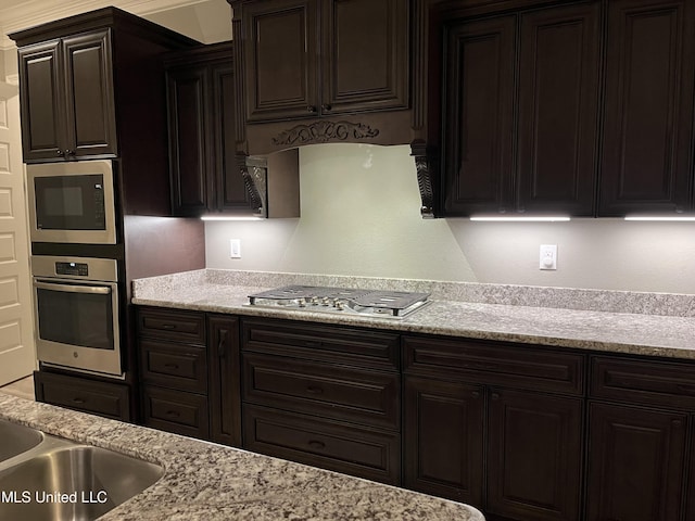 kitchen with appliances with stainless steel finishes and light stone counters