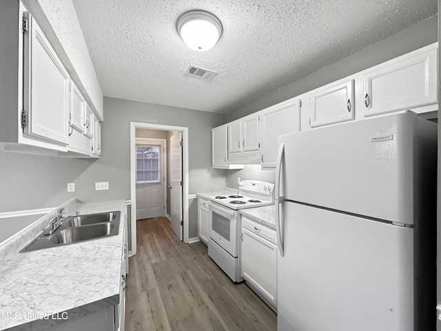 kitchen with white cabinetry, white appliances, sink, and light hardwood / wood-style flooring