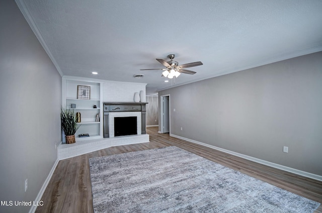 1201 Manchester Dr, Clinton, MS 39056 - unfurnished living room with crown molding, a brick fireplace, wood finished floors, baseboards, and ceiling fan