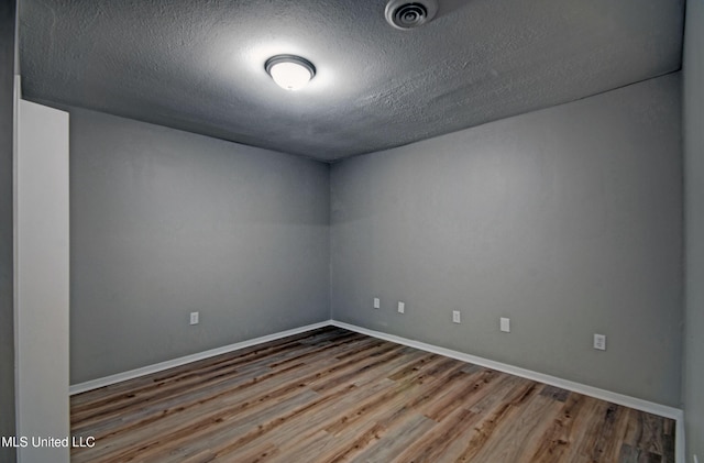 1201 Manchester Dr, Clinton, MS 39056 - unfurnished room featuring baseboards, a textured ceiling, and wood finished floors
