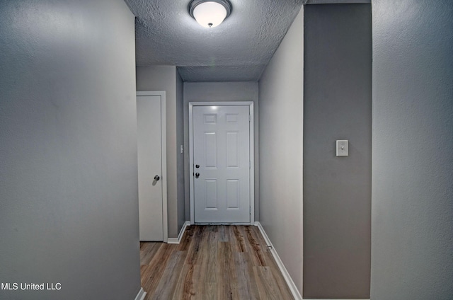 1201 Manchester Dr, Clinton, MS 39056 - doorway to outside with baseboards, a textured ceiling, and wood finished floors