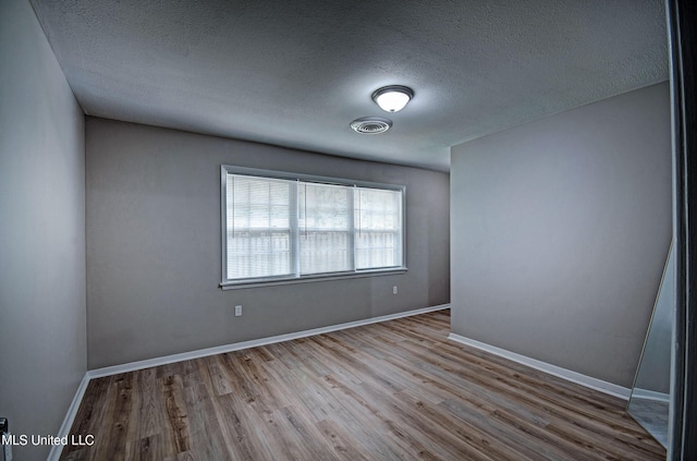 1201 Manchester Dr, Clinton, MS 39056 - spare room featuring a textured ceiling, baseboards, wood finished floors, and visible vents