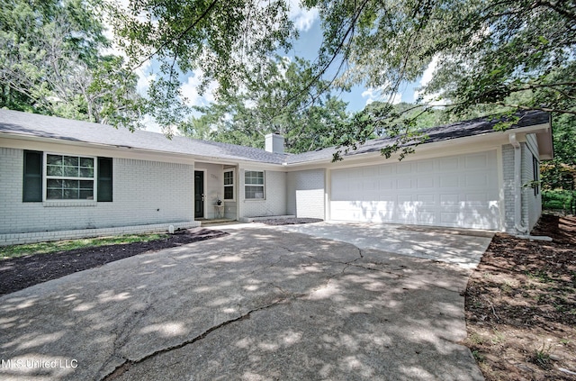 1201 Manchester Dr, Clinton, MS 39056 - ranch-style house featuring an attached garage, a chimney, concrete driveway, and brick siding