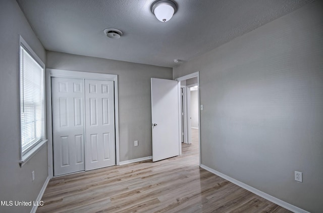 1201 Manchester Dr, Clinton, MS 39056 - unfurnished bedroom featuring baseboards, multiple windows, wood finished floors, and a closet