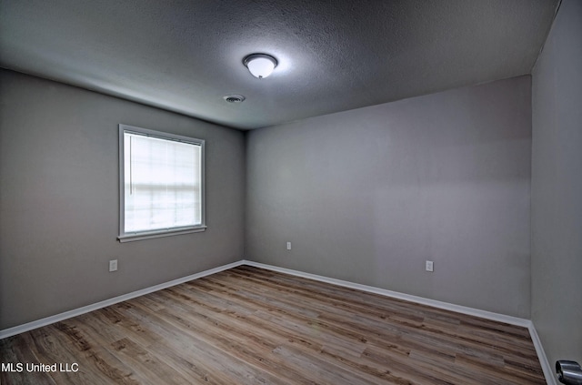 1201 Manchester Dr, Clinton, MS 39056 - unfurnished room with baseboards, a textured ceiling, wood finished floors, and visible vents