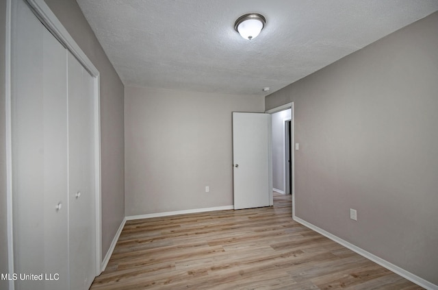 1201 Manchester Dr, Clinton, MS 39056 - unfurnished bedroom featuring baseboards, a textured ceiling, wood finished floors, and a closet