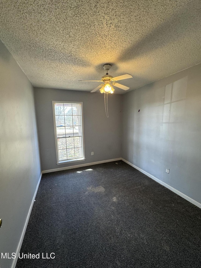 empty room featuring ceiling fan, baseboards, dark colored carpet, and a textured ceiling