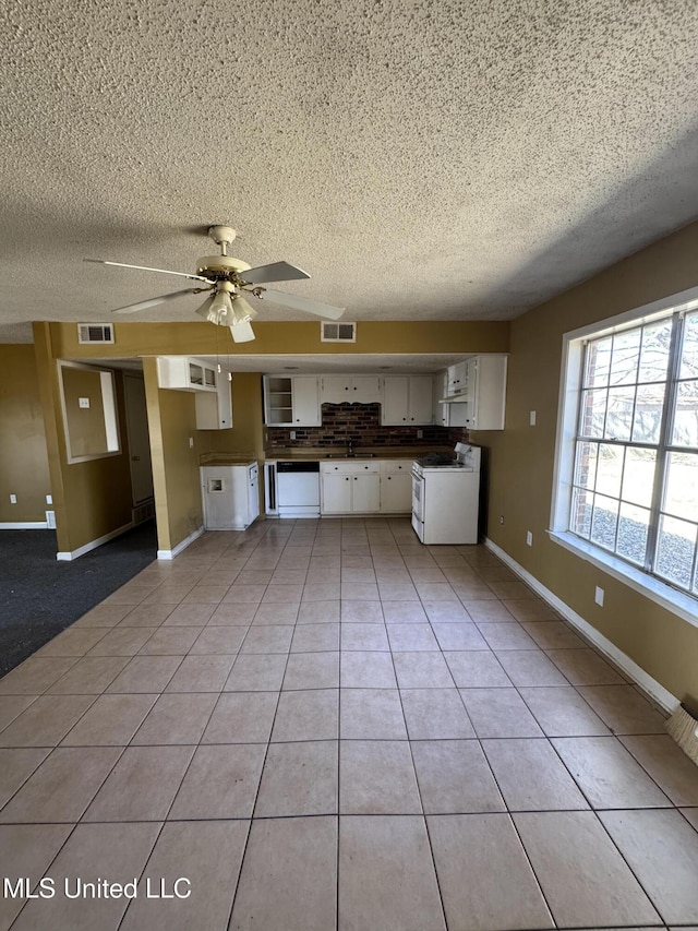 kitchen featuring light tile patterned floors, white appliances, visible vents, and white cabinets