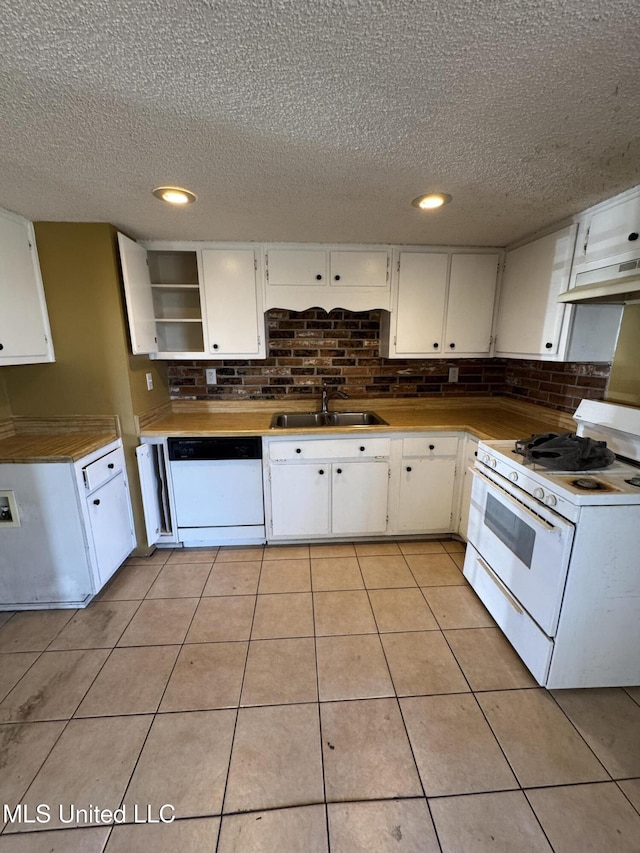 kitchen with backsplash, light tile patterned flooring, a sink, white appliances, and under cabinet range hood