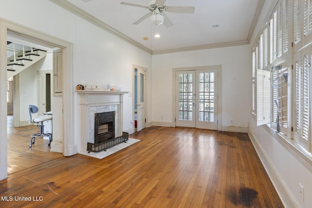 unfurnished living room featuring baseboards, ornamental molding, french doors, a ceiling fan, and wood-type flooring