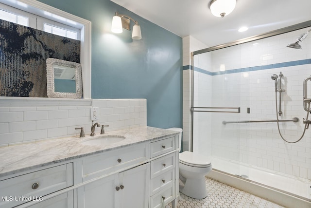 bathroom with toilet, a stall shower, and vanity