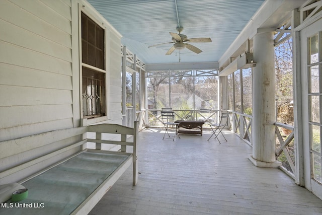 unfurnished sunroom with a ceiling fan