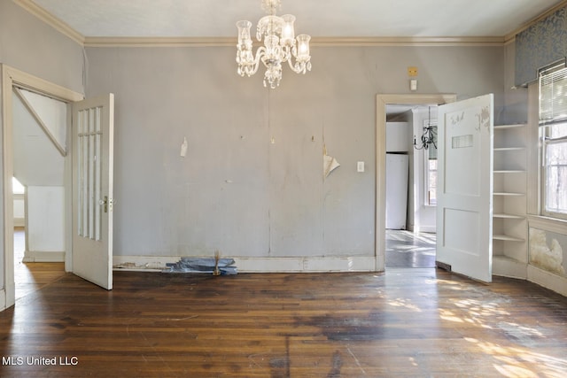 spare room with an inviting chandelier, wood finished floors, and ornamental molding