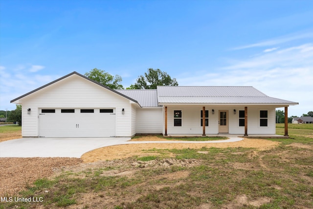 view of front of house with covered porch, a front lawn, and a garage