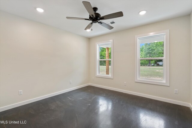 spare room with dark hardwood / wood-style floors, a healthy amount of sunlight, and ceiling fan