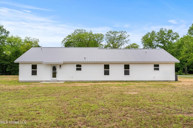 rear view of property featuring a lawn