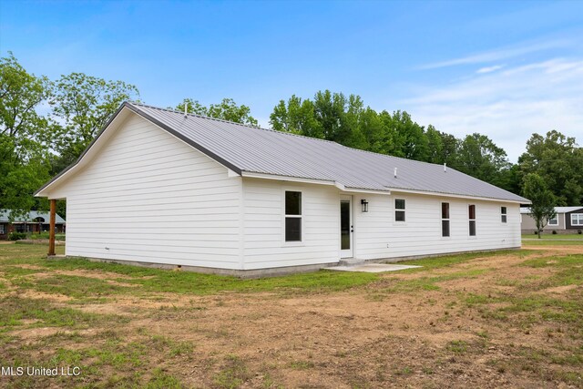 rear view of property with a lawn