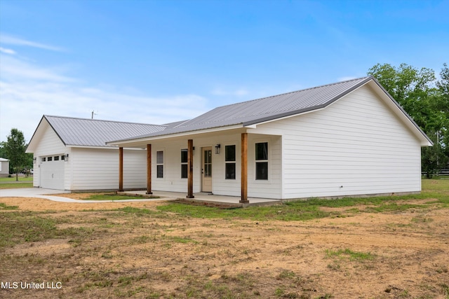 view of front of home featuring a porch, a front lawn, and a garage