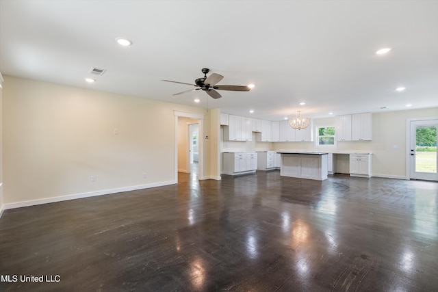 unfurnished living room with dark hardwood / wood-style floors and ceiling fan with notable chandelier