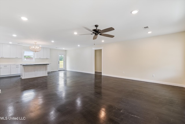 unfurnished living room with dark wood-type flooring and ceiling fan with notable chandelier