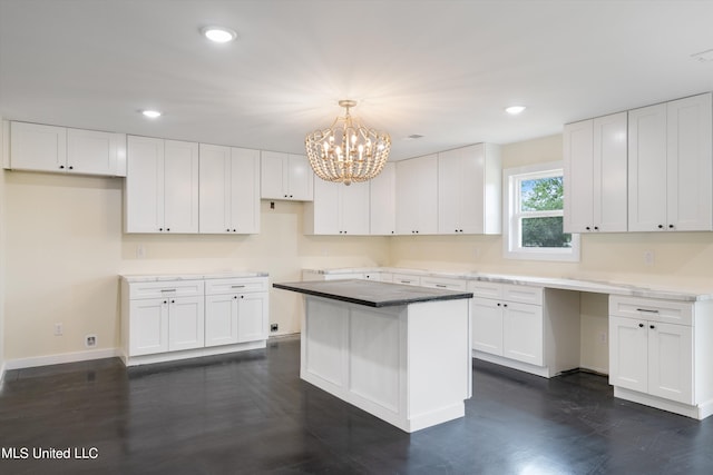 kitchen with a notable chandelier, a center island, white cabinetry, and hanging light fixtures