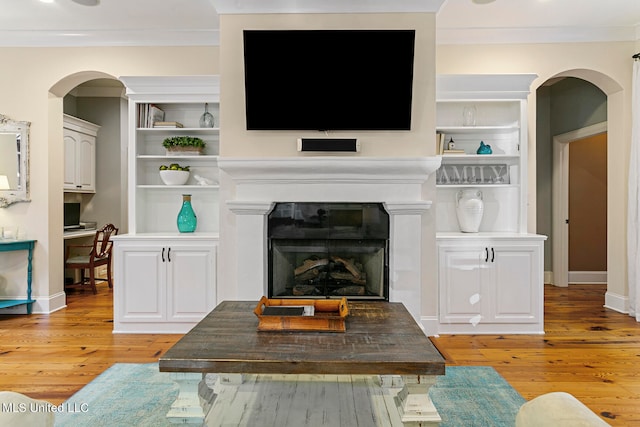 living room with ornamental molding and light hardwood / wood-style flooring